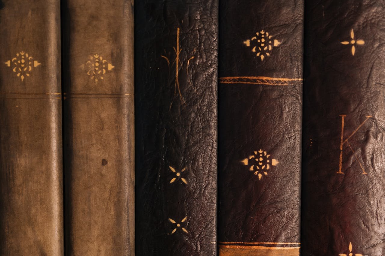 Detailed view of vintage leather-bound books with ornamental designs on spines.